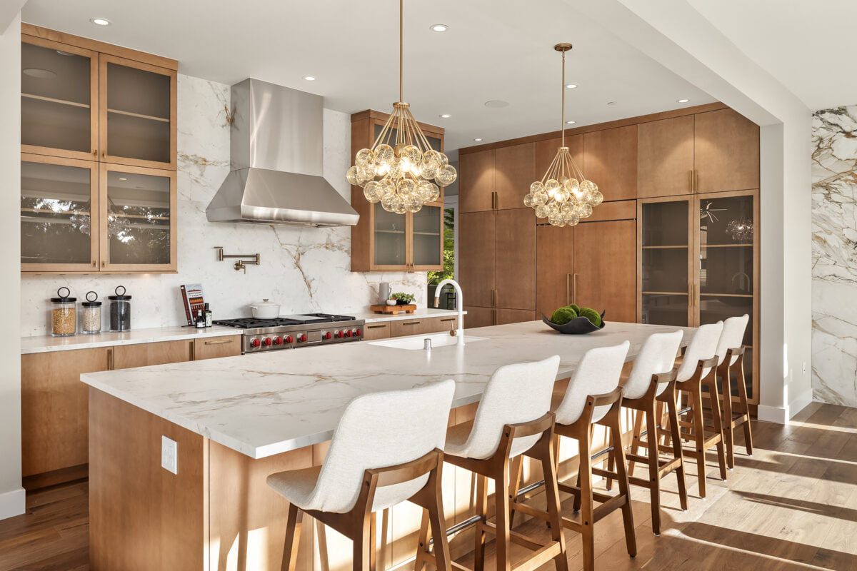 Modern kitchen featuring elegant design, rich wood cabinetry, marble surfaces, and stylish pendant lighting.