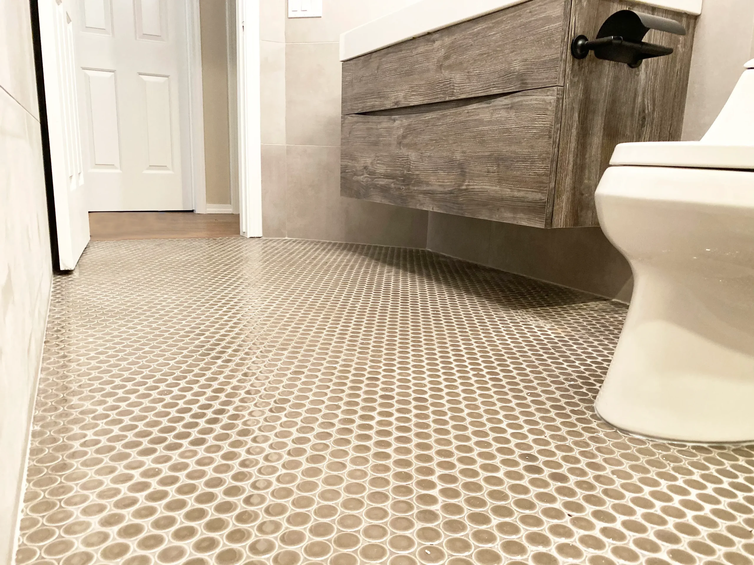 Bathroom with honeycomb tiles and warm wood vanity — Ariana Designs, Seattle