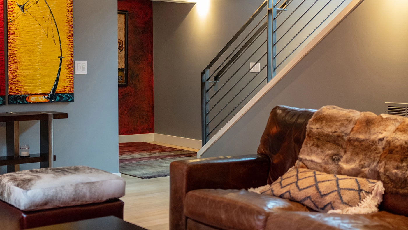 Cozy modern living space leather sofa staircase — Ariana Designs, Seattle Washington