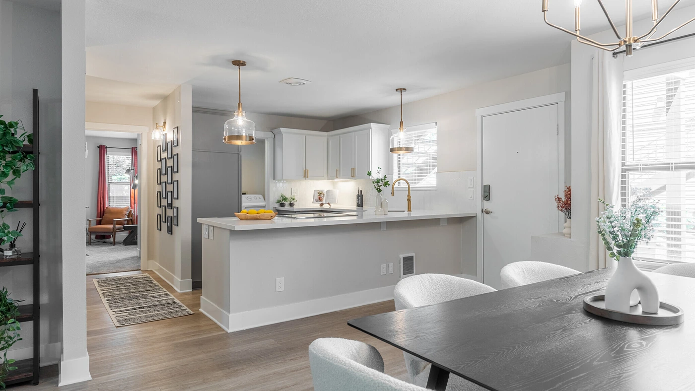 Bright modern kitchen and dining area featuring elegant decor, natural light, and cozy furniture.