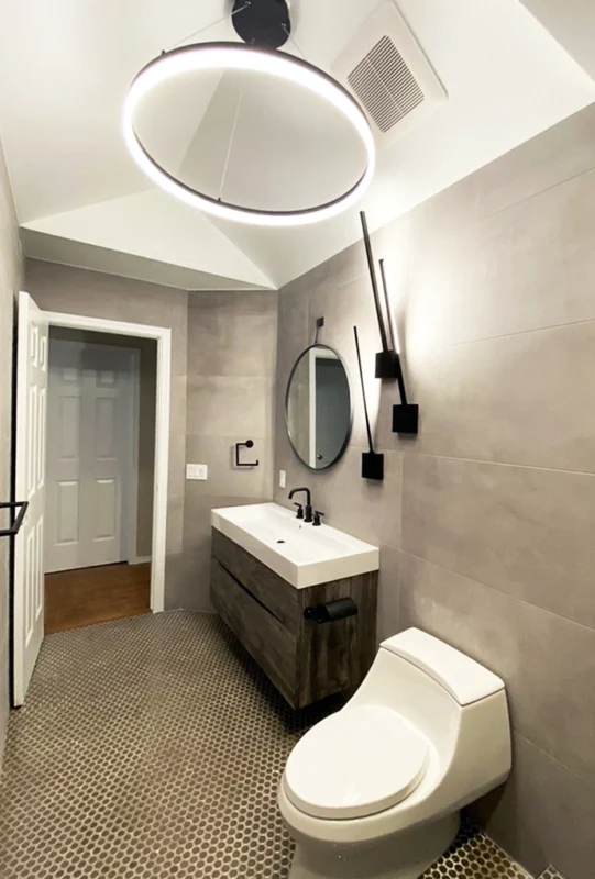 Minimalist bathroom with gray tile and sleek fixtures — Ariana Designs