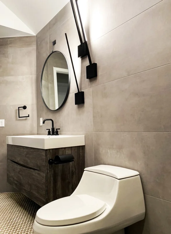 Gray tile bathroom with wood vanity and black fixtures — Ariana Designs