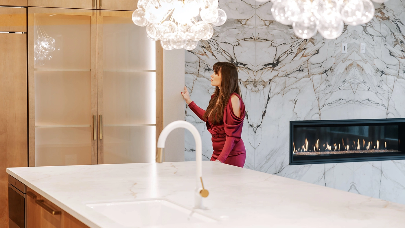 Luxurious modern kitchen featuring marble countertops, elegant cabinetry, and a cozy fireplace ambiance.