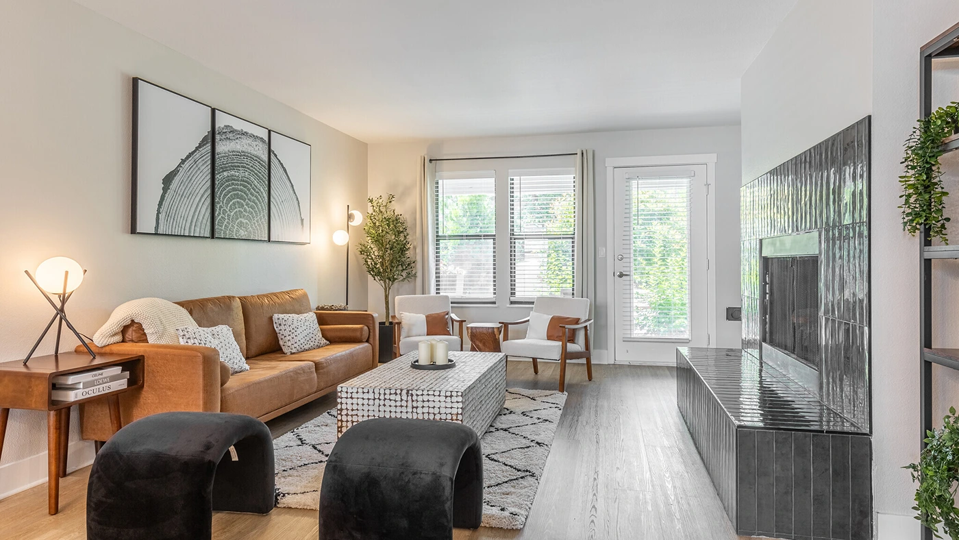 Modern cozy living room with a leather sofa, stylish armchairs, and natural light.