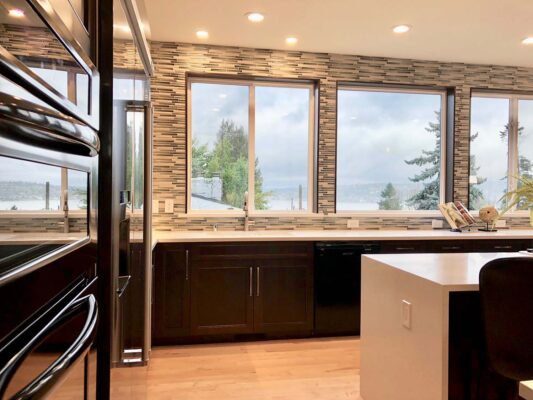 Elegant dining area with curated accessories, warm lighting fixtures, and a view of the Pacific Northwest outdoors, reflecting sophisticated interior styling.