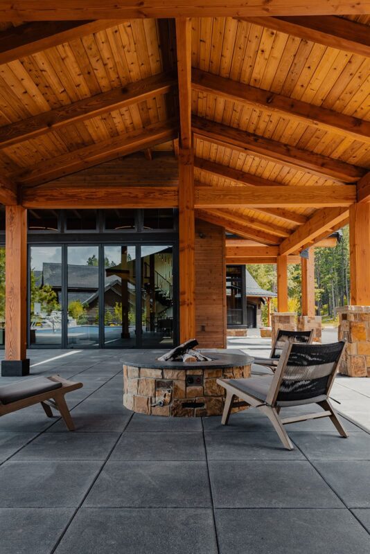 Cozy outdoor seating area with fire pit, modern chairs, and seamless indoor-outdoor connection.