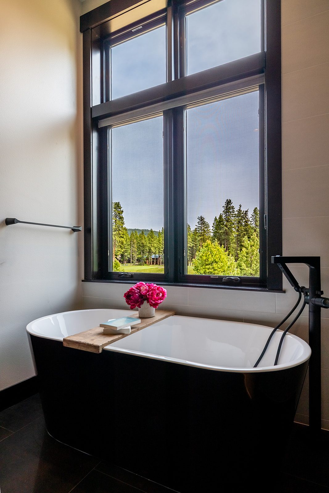Freestanding matte black tub and illuminated vanity — Ariana Designs & Interiors, Suncadia