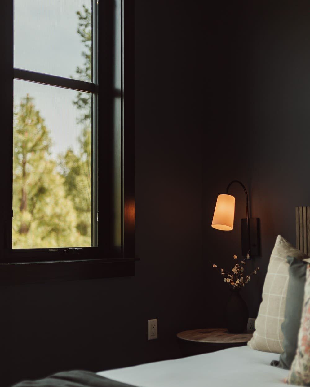 Guest room with forest views and black-framed windows — Suncadia