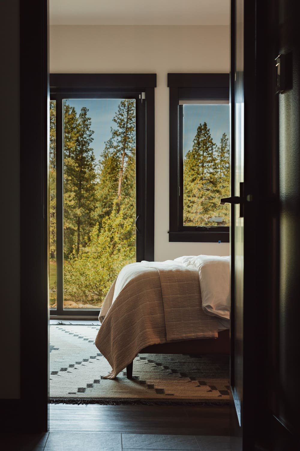 Blue guest bedroom with navy walls and wood slat headboard — Suncadia