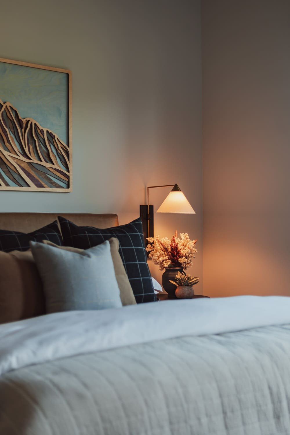 Primary bedroom detail with layered pillows and balcony view — Suncadia