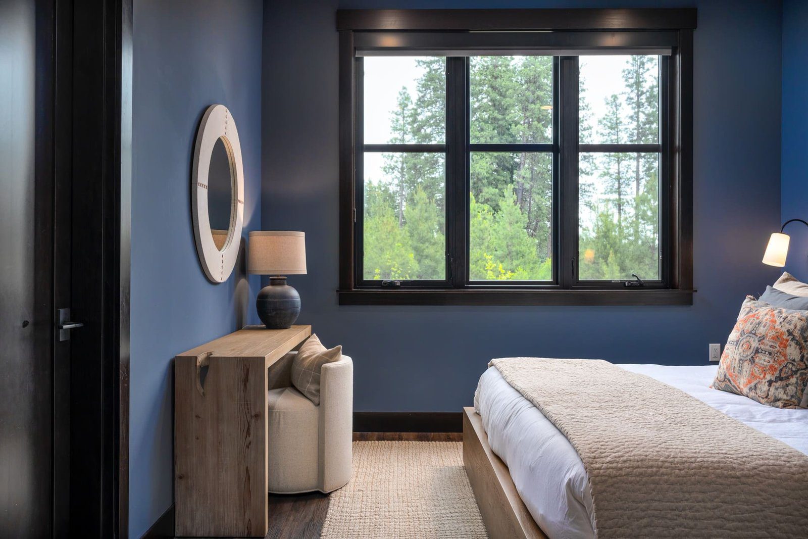 Guest bedroom with deep navy walls and wood slat headboard — Suncadia