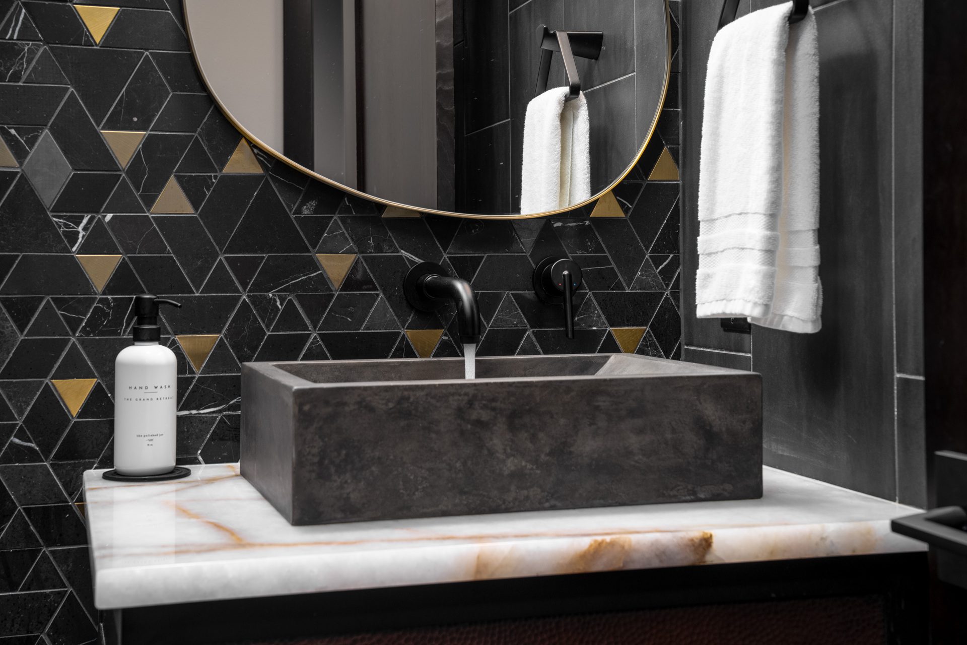 Full view of Suncadia luxury powder room — black marble, brass, onyx — Ariana Designs